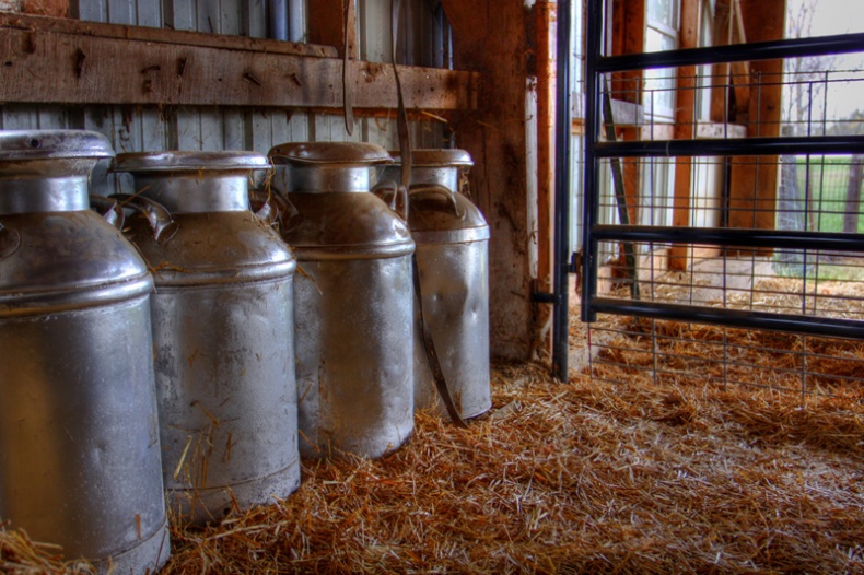 Milk jugs in a barn by Kyle Hickman